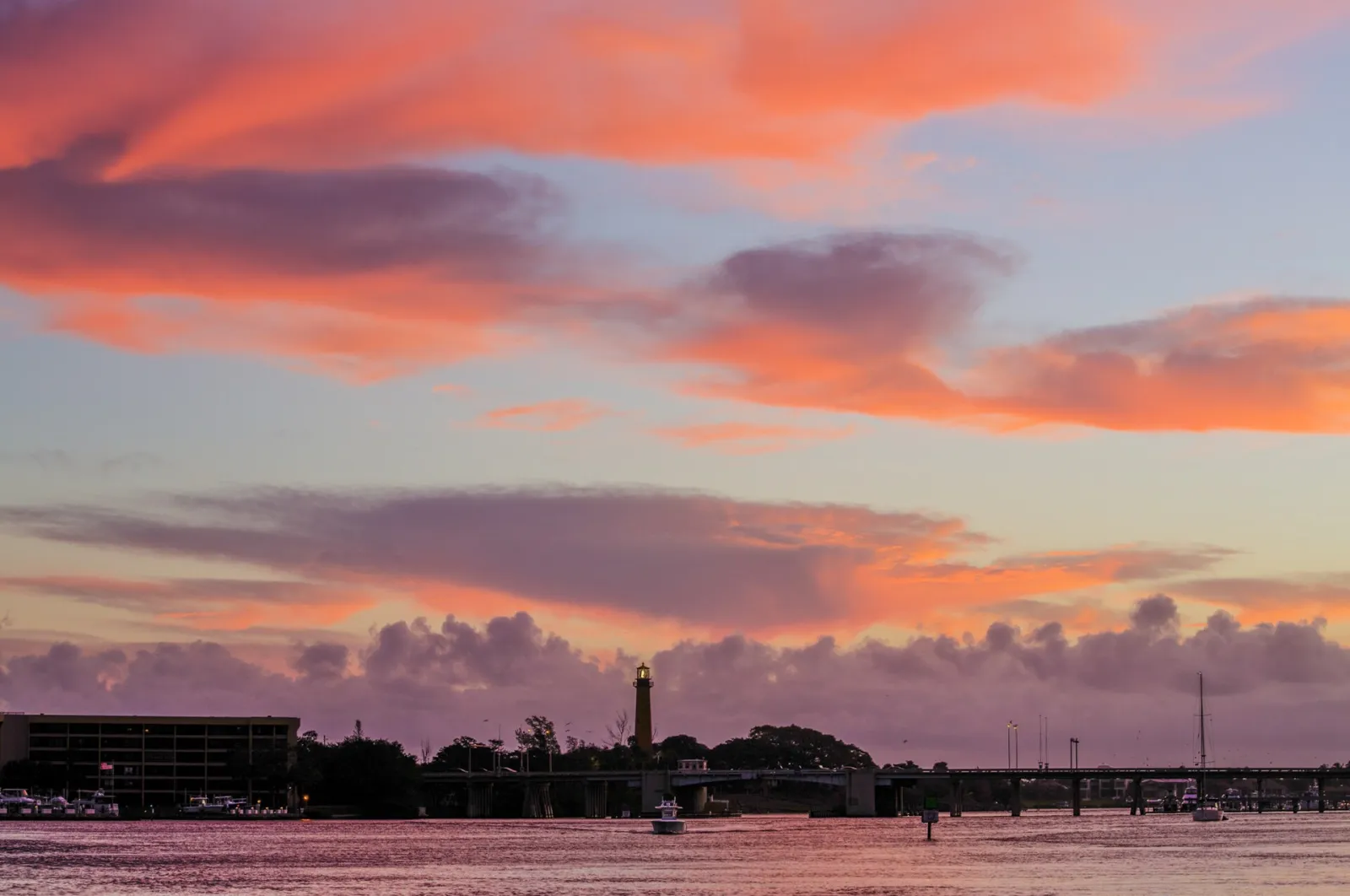 The Jupiter Inlet Lighthouse silhouetted against a sunset sky above the inlet in Jupiter.