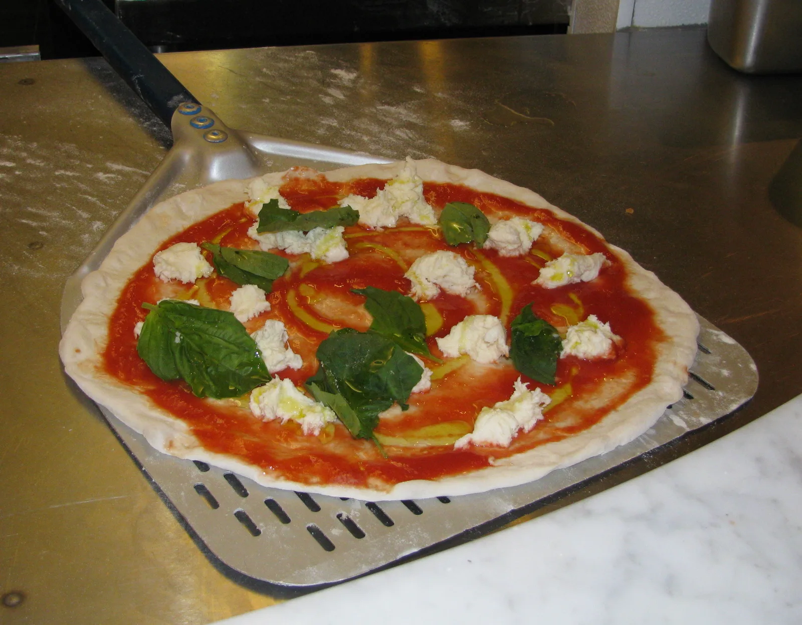 A Margherita-style pizza on a peel, ready for the oven. The photo was not taken at a Jupiter restaurant.